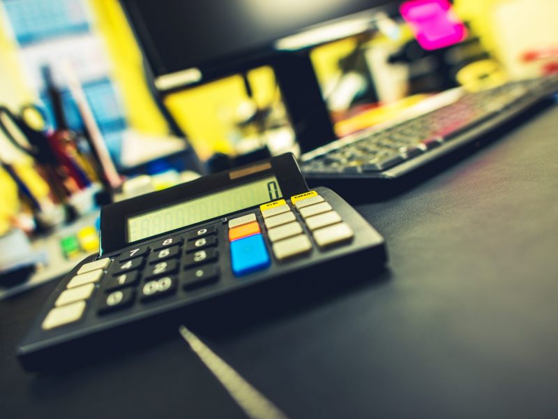Office and Accounting Concept. Compact Calculator Device on the Accountant Desk.